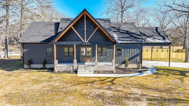 view of front of house with french doors, a front lawn, a porch, and a carport