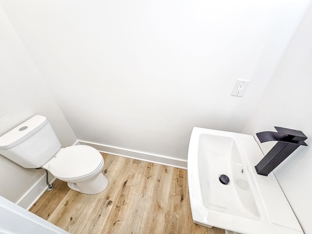 bathroom featuring toilet and wood-type flooring