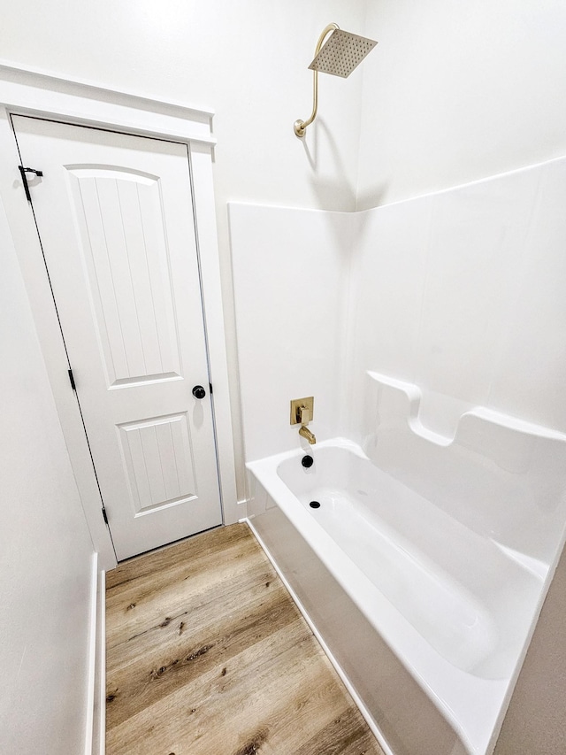 bathroom featuring bathtub / shower combination and wood-type flooring