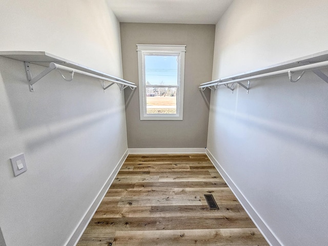 spacious closet with hardwood / wood-style flooring