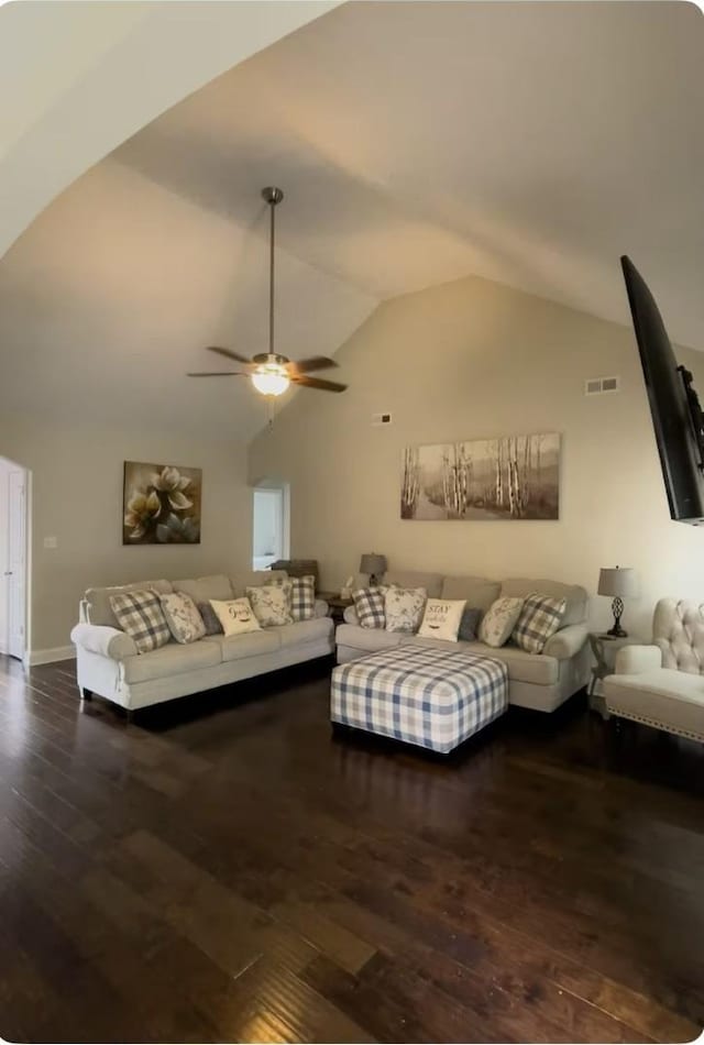 living room with ceiling fan, dark wood-type flooring, and vaulted ceiling