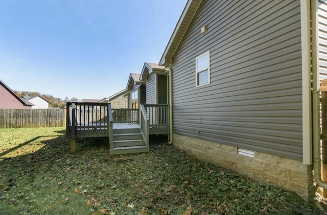 view of side of property featuring a deck and a lawn