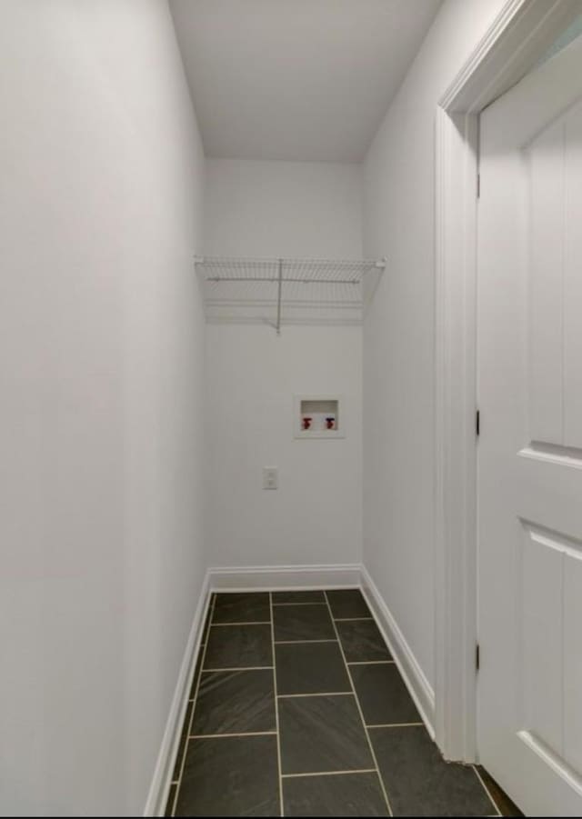 washroom featuring washer hookup and dark tile patterned floors