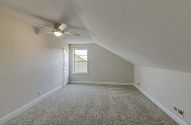 additional living space with ceiling fan, light carpet, and vaulted ceiling