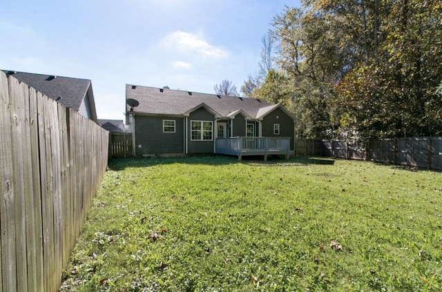 rear view of property featuring a deck and a yard