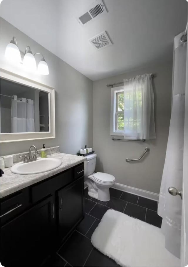 bathroom featuring toilet, vanity, and tile patterned flooring