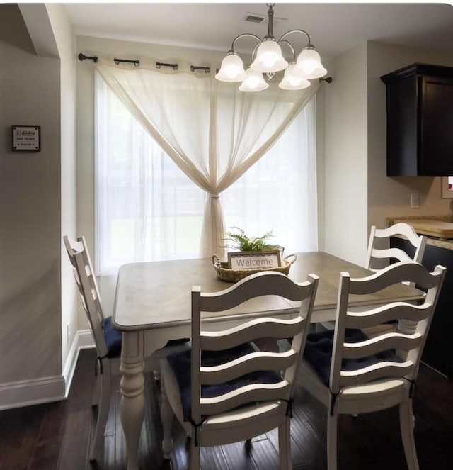 dining area with dark hardwood / wood-style flooring and a chandelier