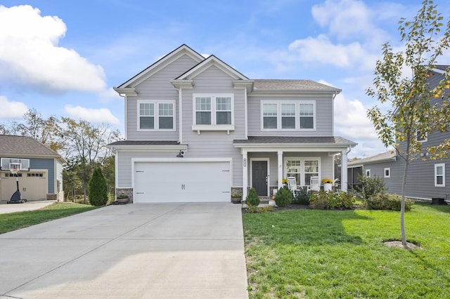 view of front of property featuring a garage, a front yard, and covered porch