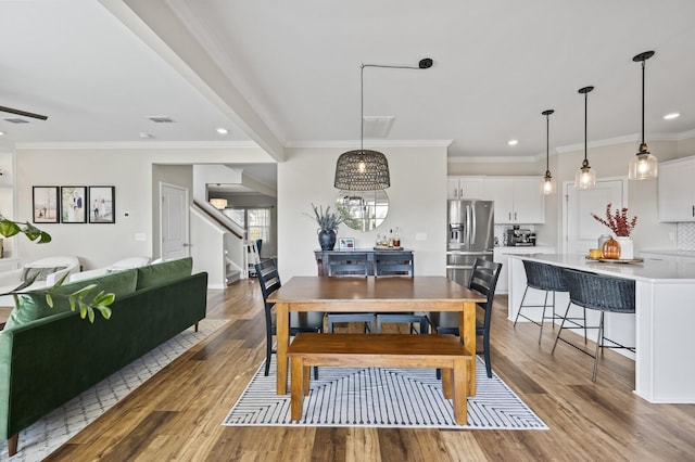 dining room featuring crown molding and light hardwood / wood-style floors