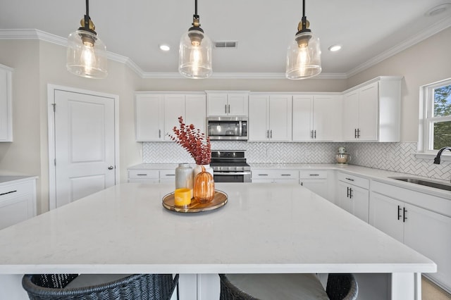 kitchen with decorative light fixtures, a kitchen bar, sink, and stainless steel appliances