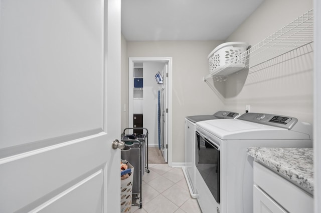 clothes washing area featuring light tile patterned floors and independent washer and dryer