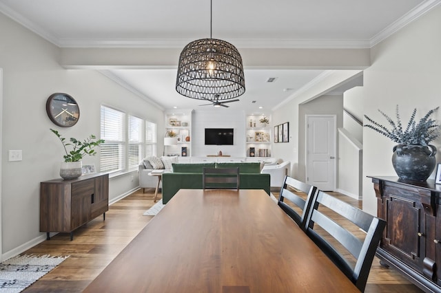 dining room with built in features, ornamental molding, a chandelier, and hardwood / wood-style floors