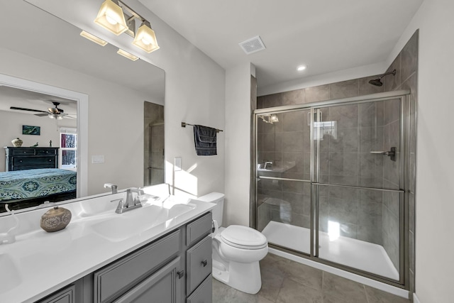 bathroom featuring toilet, tile patterned floors, a shower with door, and vanity