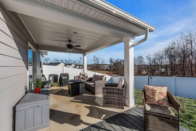 view of patio with ceiling fan, a deck, central air condition unit, and an outdoor living space with a fire pit