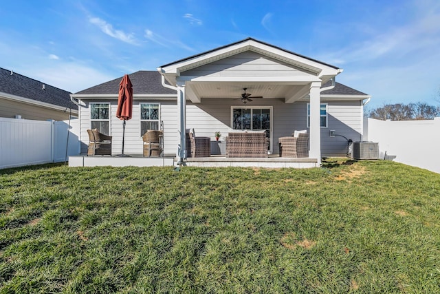 rear view of house with ceiling fan, central AC unit, a patio area, and a yard