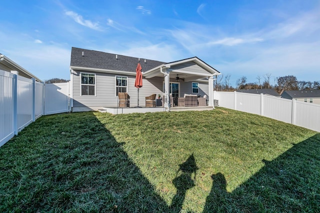 rear view of property with a lawn, ceiling fan, and a patio area