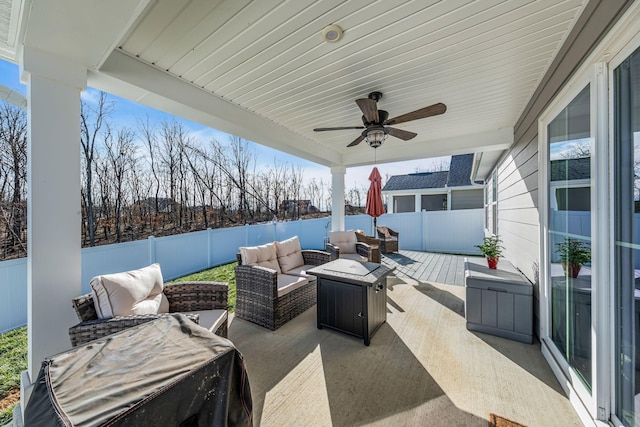 view of patio with ceiling fan and an outdoor living space with a fire pit