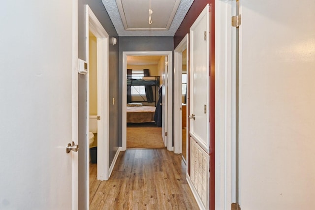 hallway featuring a textured ceiling and light wood-type flooring