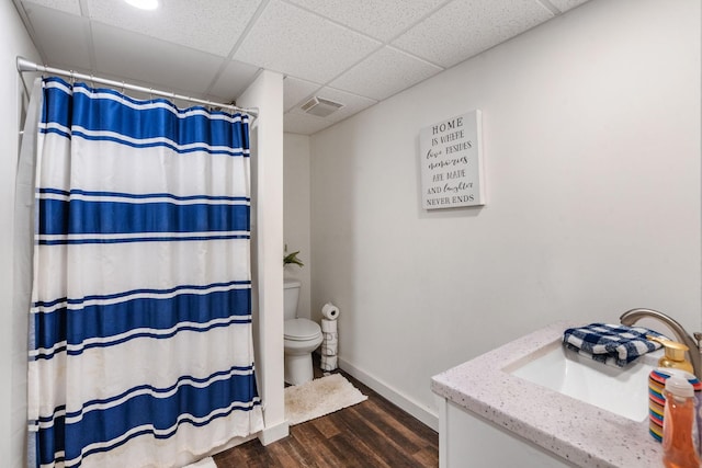 bathroom with toilet, hardwood / wood-style floors, a paneled ceiling, a shower with curtain, and vanity