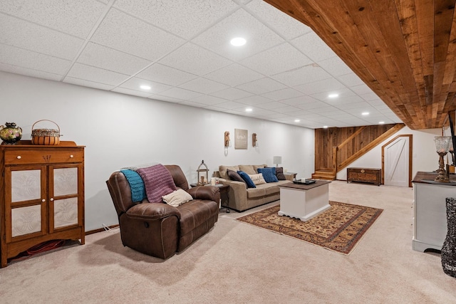 living room with a paneled ceiling and carpet flooring