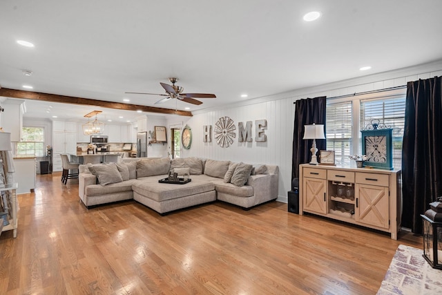 living room featuring ceiling fan, beamed ceiling, and light wood-type flooring