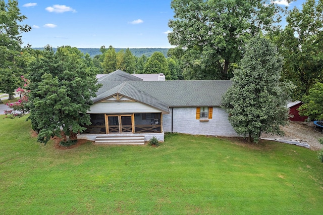 back of property featuring a sunroom and a yard