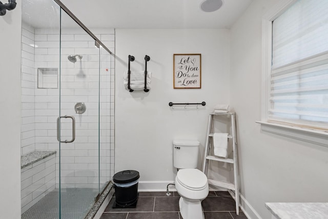 bathroom featuring toilet, tile patterned flooring, and a shower with shower door