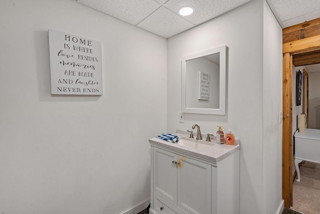 bathroom with a drop ceiling and vanity