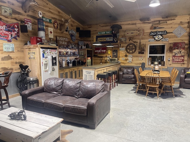 living room featuring wood walls and concrete floors