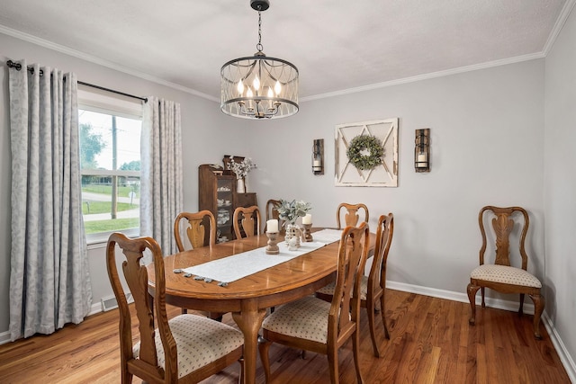 dining space featuring ornamental molding, a chandelier, and hardwood / wood-style floors