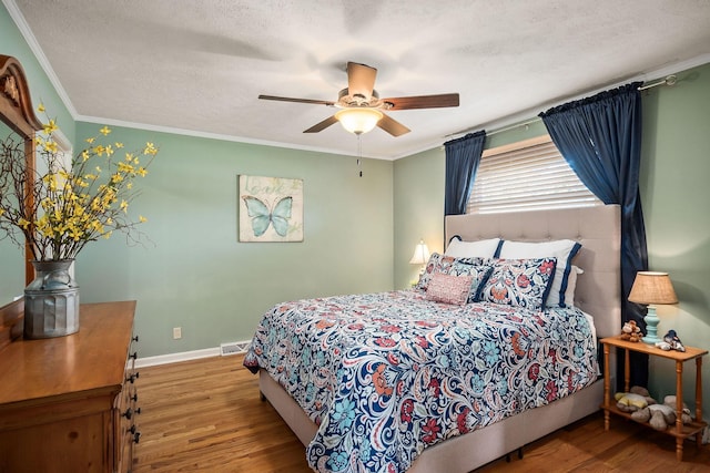 bedroom featuring a textured ceiling, ceiling fan, crown molding, and hardwood / wood-style flooring