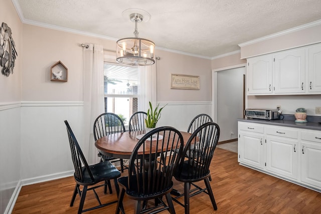 dining room featuring a chandelier, crown molding, a textured ceiling, and hardwood / wood-style floors