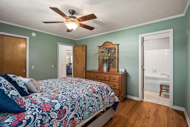 bedroom with ceiling fan, connected bathroom, ornamental molding, and hardwood / wood-style floors