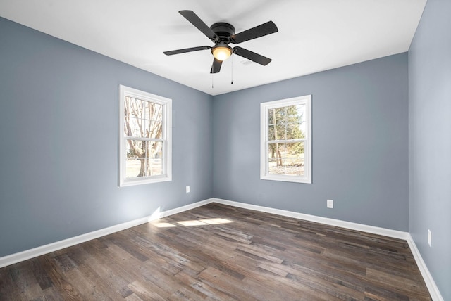 empty room with ceiling fan and dark hardwood / wood-style flooring