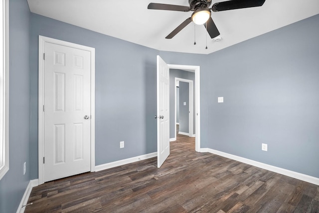 unfurnished bedroom featuring ceiling fan and dark hardwood / wood-style floors