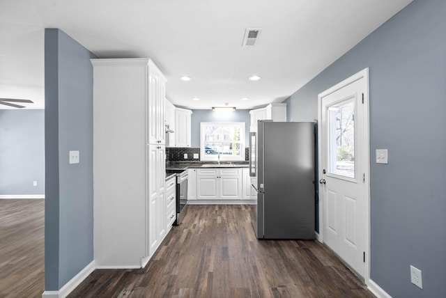 kitchen featuring stainless steel appliances, a healthy amount of sunlight, white cabinets, and sink