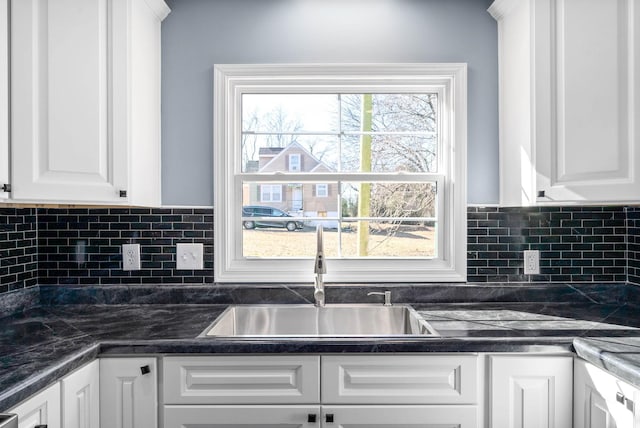 kitchen featuring decorative backsplash, sink, and white cabinets