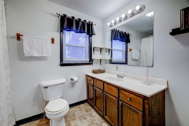 bathroom featuring toilet, vanity, and a textured ceiling