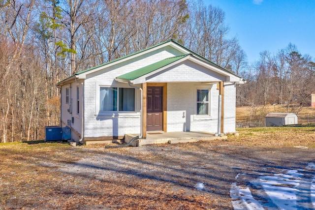 view of front of house featuring a porch and a shed