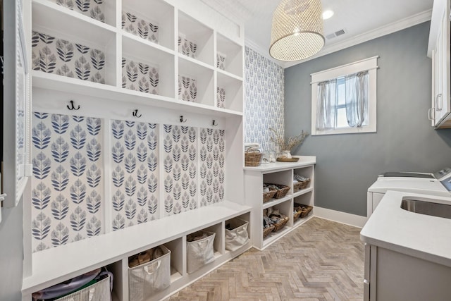 mudroom with washing machine and dryer, light parquet floors, sink, and ornamental molding