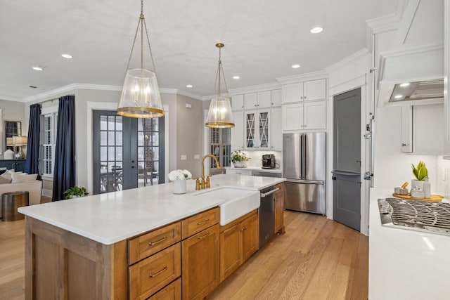 kitchen featuring white cabinetry, appliances with stainless steel finishes, a spacious island, custom range hood, and sink