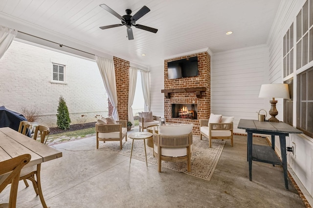 living room with ceiling fan, brick wall, an outdoor brick fireplace, concrete flooring, and crown molding