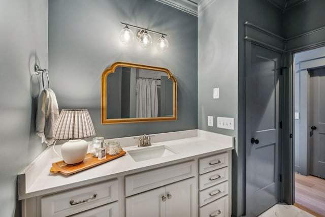 bathroom with curtained shower, vanity, and ornamental molding