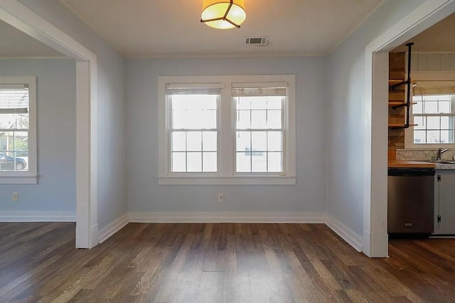 unfurnished dining area featuring sink, dark wood-type flooring, and plenty of natural light