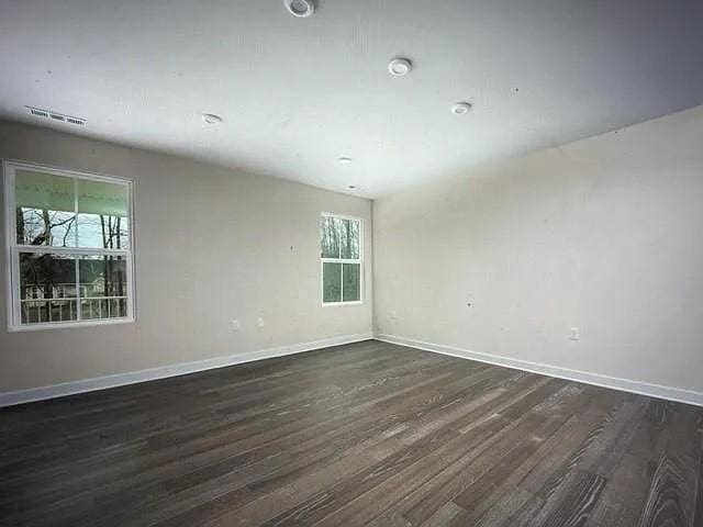 spare room with dark wood-type flooring