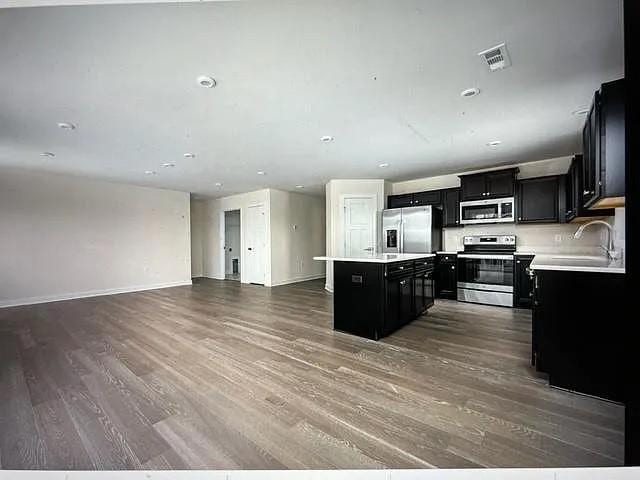 kitchen featuring hardwood / wood-style flooring, sink, appliances with stainless steel finishes, and a center island