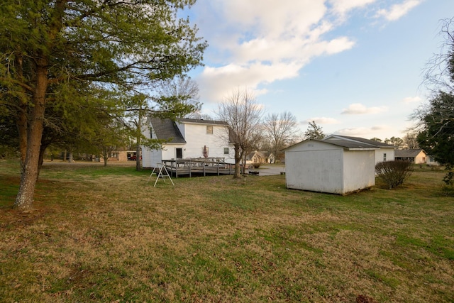 view of yard featuring a wooden deck and a shed