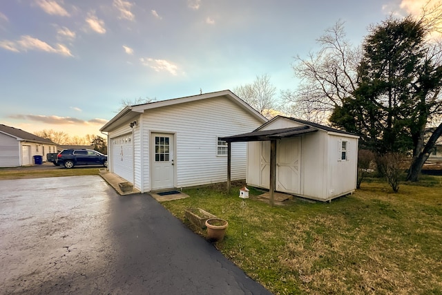 exterior space featuring a lawn and an outbuilding