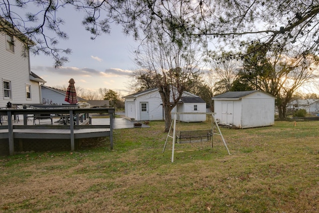 yard at dusk featuring a deck and a storage shed