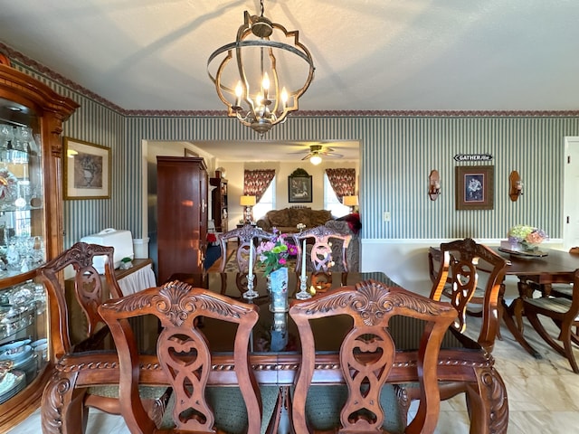 dining room with ceiling fan with notable chandelier and a textured ceiling